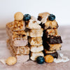 Coconut white chocolate, chocolate, blueberry white chocolate & cocnut white chocolate macadamia snack bar by House of Macadamias, made with macadamias as the first ingredient. Plant based, no seed oils, 100% natural healthy snack bar rich in antioxidants and healthy fats.