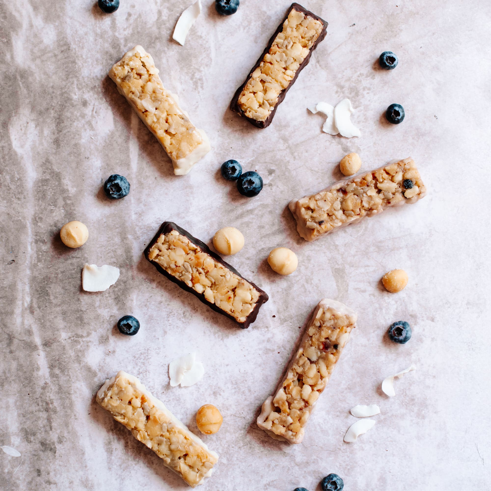 Coconut white chocolate, chocolate, blueberry white chocolate & cocnut white chocolate macadamia snack bar by House of Macadamias, made with macadamias as the first ingredient. Plant based, no seed oils, 100% natural healthy snack bar rich in antioxidants and healthy fats.
