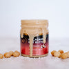 House of Macadamias Sea Salt Macadamia Nut Butter spilling from the jar, styled with whole macadamia nuts and sea salt crystals