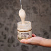 House of Macadamias White Chocolate Macadamia Nut Butter spoon dripping creamy butter back into the jar