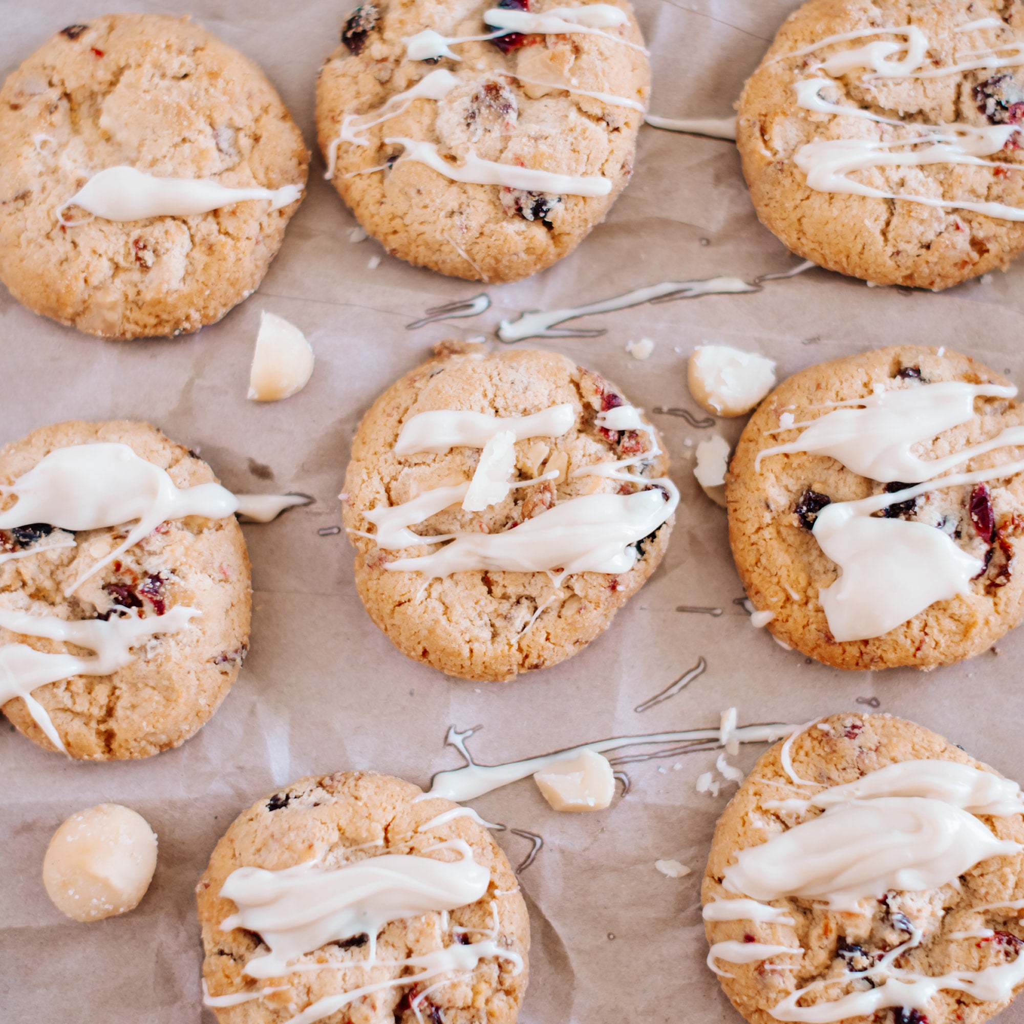 White Chocolate Macadamia Nut Butter drizzled over macadamia nut cookies on a plate, no packaging visible